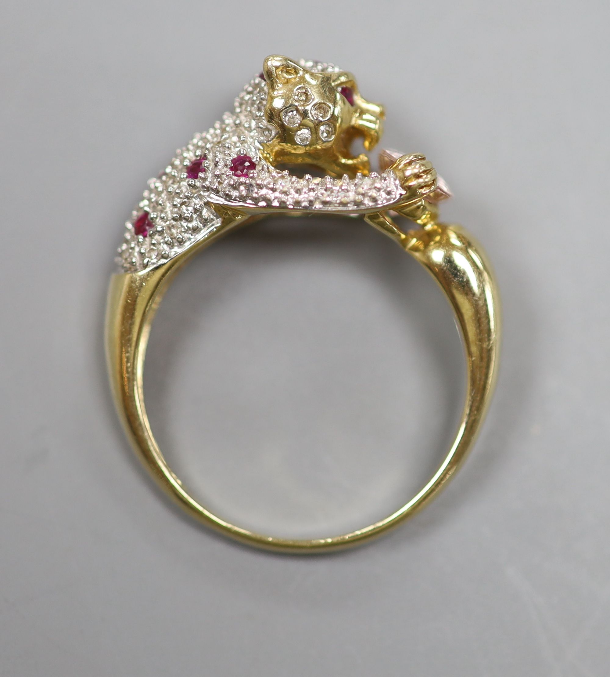 A modern Cartier style 585 yellow metal, pink topaz?, ruby and diamond encrusted leopard ring